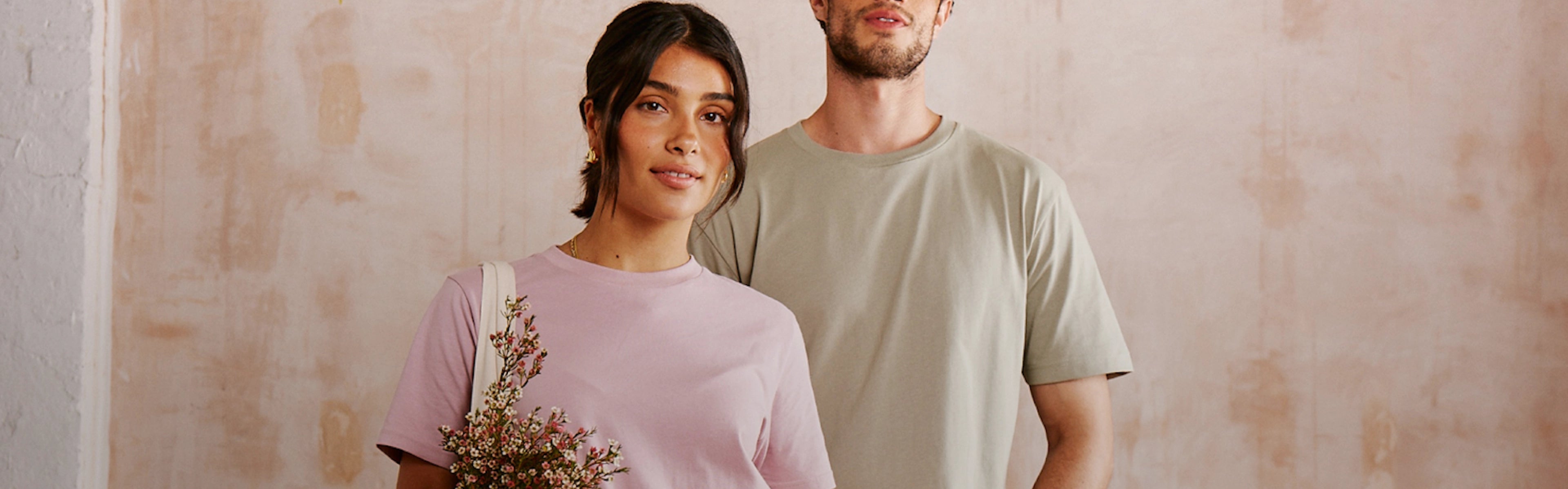 A male and a female model wearing Earth Positive Sustainable T-Shirts.